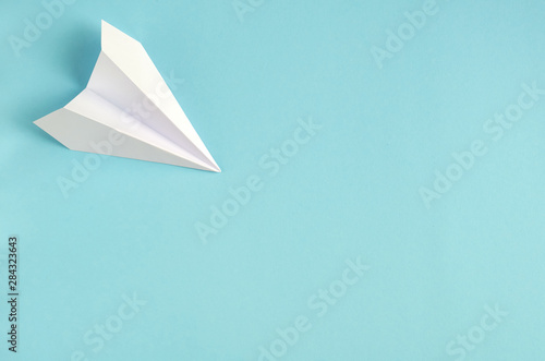 White paper plane on blue background composition. © Sviatoslav Kovtun