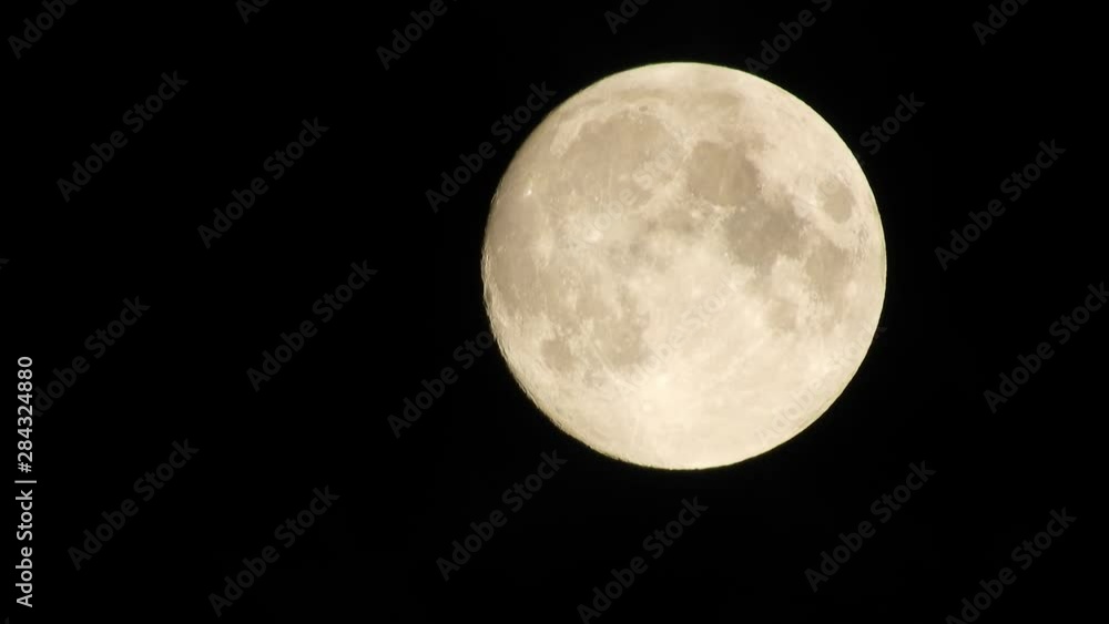 Full moon and clouds on a summer night sky. Moon With Clouds In The Night Sky. Full moon shining through the clouds Full moon and clouds on a summer night sky. Moon With Clouds In The Night Sky. Full moon shining through the clouds