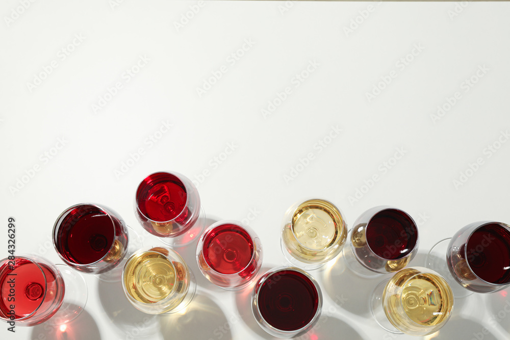 Flat lay composition. Glasses with different wine on white background, top view Flat lay composition. Glasses with different wine on white background, top view