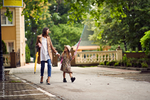 smiling mother and daughter walking from school