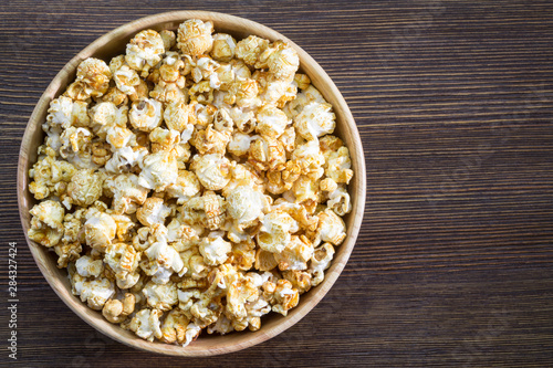 Corn popcorn in bowl on wooden background