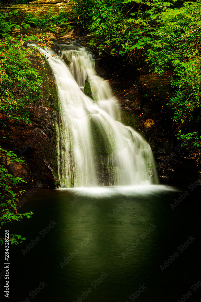 Obraz premium Water cascades over Blue Hole Falls in Hiawassee, Georgia.
