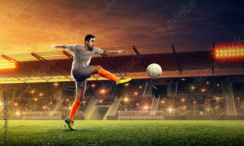 Soccer player in action on a stadium. Kicking the ball. Soccer game. Sports championship. Soccer field.