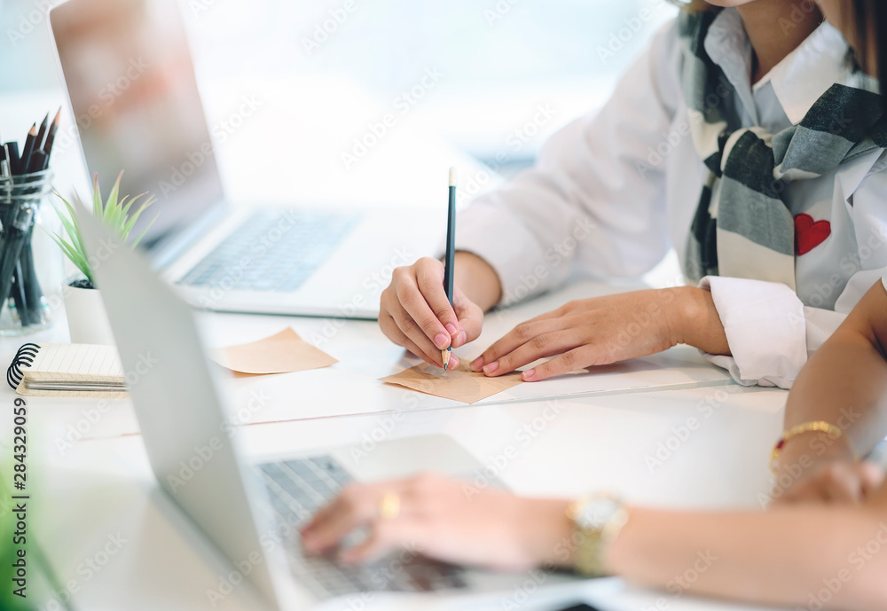woman writing on notepad with pencil while working in office. woman writing on notepad with pencil while working in office.