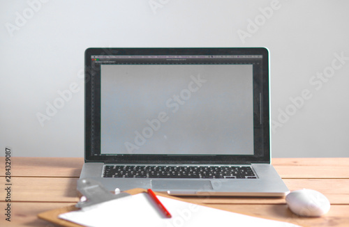 Laptop stands on a wooden table in office