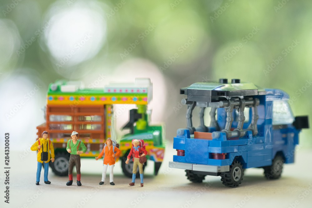Miniature people : Traveller backpacker standing with Thai farming trucks and Thai style taxi.