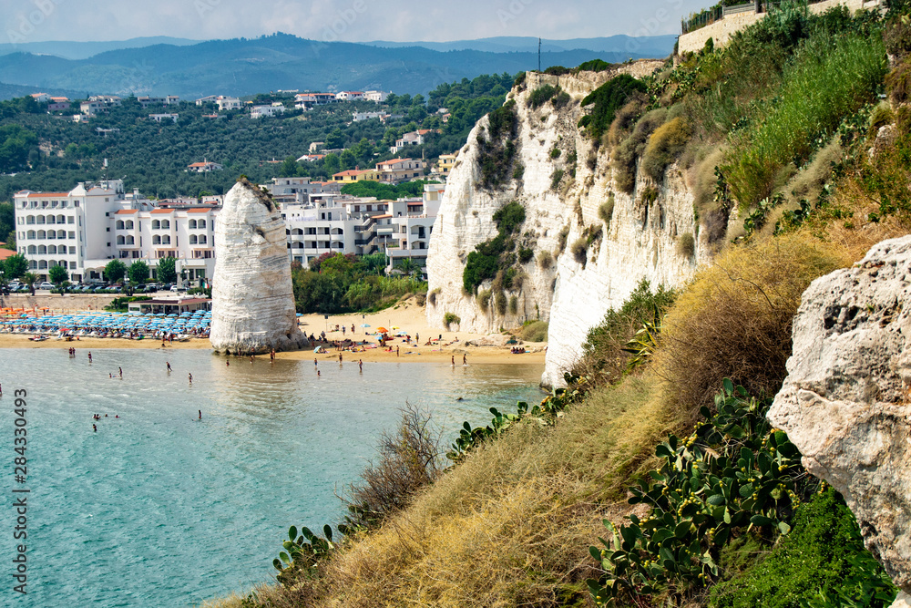 Vieste, Gargano, Apulia, Pizzomunno monolith on the seashore with parasols
