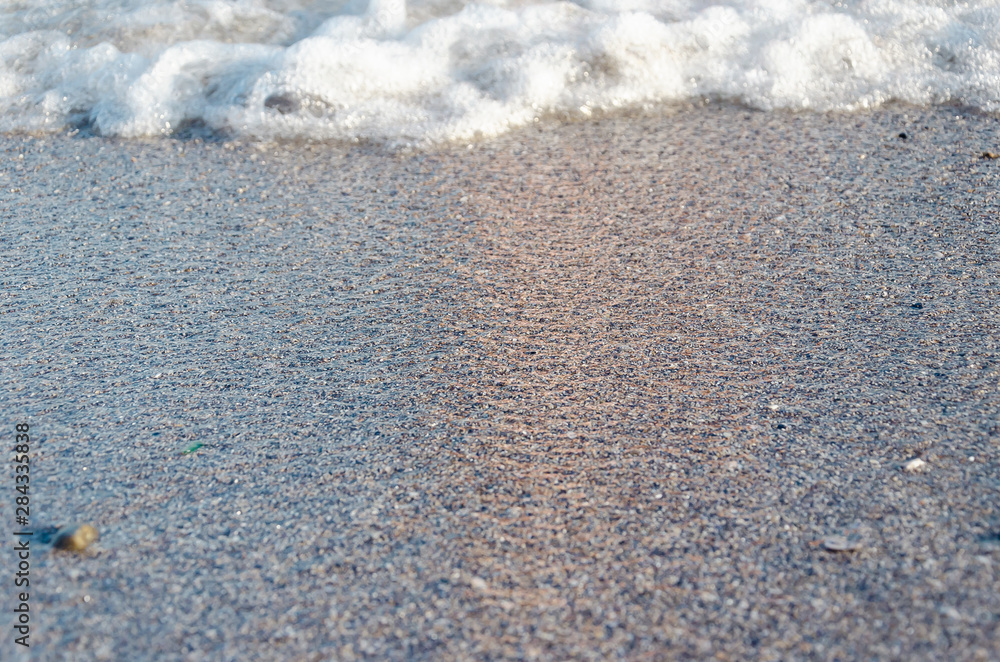Closeup of sandy beach with soft incoming waves. Selective focus Closeup of sandy beach with soft incoming waves. Selective focus