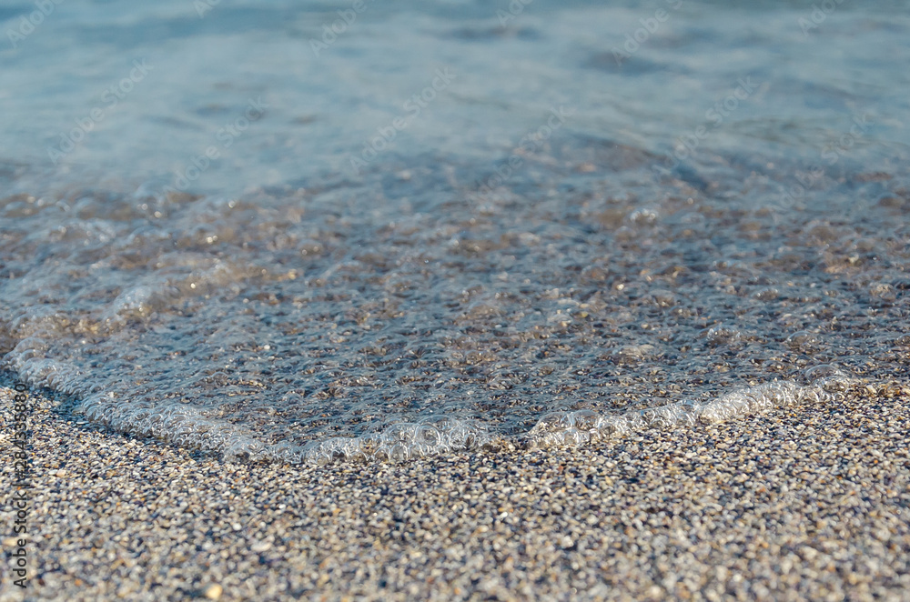 Closeup of sandy beach with soft incoming waves. Selective focus Closeup of sandy beach with soft incoming waves. Selective focus