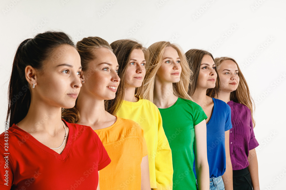 Young women weared in LGBT flag colors isolated on white background. Caucasian female models in bright shirts. Look happy, smiling. Trust LGBT pride, human rights, freedom of choice concept. Young women weared in LGBT flag colors isolated on white background. Caucasian female models in bright shirts. Look happy, smiling. Trust LGBT pride, human rights, freedom of choice concept.