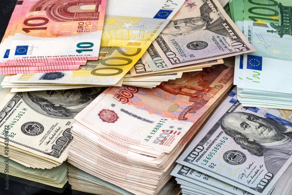 Bundles of money in three currencies Bundles of money in three currencies
