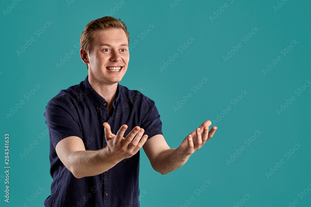 Close-up portrait of a ginger guy in navy t-shirt posing on blue background. Sincere emotions. Close-up portrait of a ginger guy in navy t-shirt posing on blue background. Sincere emotions.