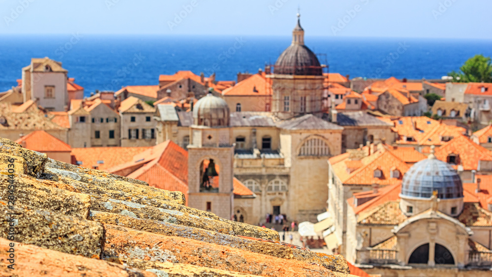 Fototapeta premium Summer mediterranean cityscape - view of the old roof on the background of the Old Town of Dubrovnik on the Adriatic coast of Croatia, closeup