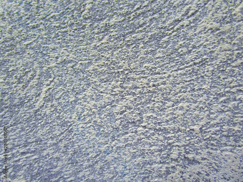  The texture of the paint on the wall. Snow blizzard. Christmas background. Snowflakes on a background of blue sky. Abstract snow pattern. New Year. 