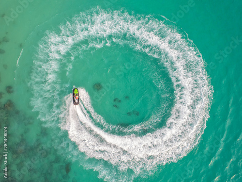 People are playing a jet ski in the sea.Aerial view. Top view.amazing nature background.The color of the water and beautifully bright. Fresh freedom. Adventure day.clear turquoise at tropical beach.