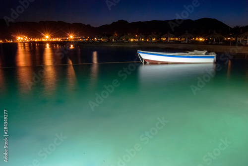 A small boat illuminated at night