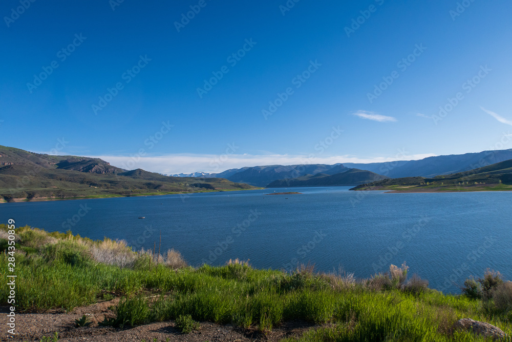 Landscape of Blue Mesa Reservoir with greenery and hills in the background near Gunnison, Colorado