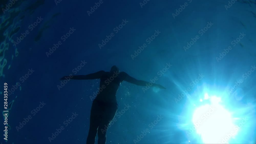 Young woman swimming in the blue and clear sea. Young woman swimming underwater Young woman swimming in the blue and clear sea. Young woman swimming underwater