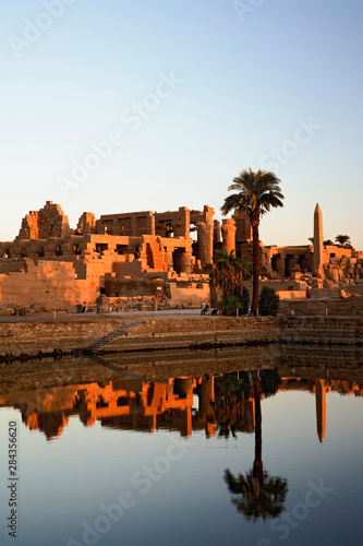 Karnak Temple and the Sacred Lake at sunrise. Karnak was the residence of gods, Amon-Re, his wife Mut, and their son Khonsu, the moon god. Built in the 12th dynasty, 2000 B. C. - 220 B. C.