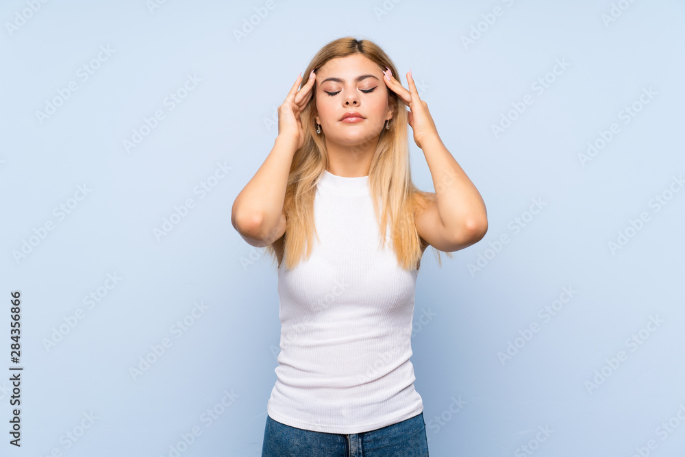 Teenager girl over isolated blue background showing thumb down with negative expression