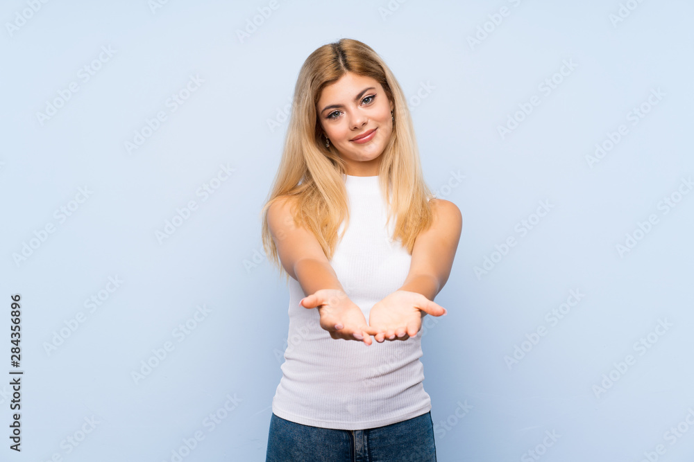 Teenager girl over isolated blue background making time out gesture Teenager girl over isolated blue background making time out gesture