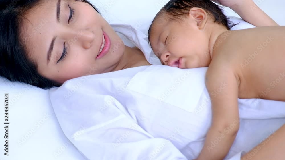 Closeup young asian mother sleeping her baby lullabies Closeup young asian mother sleeping her baby lullabies