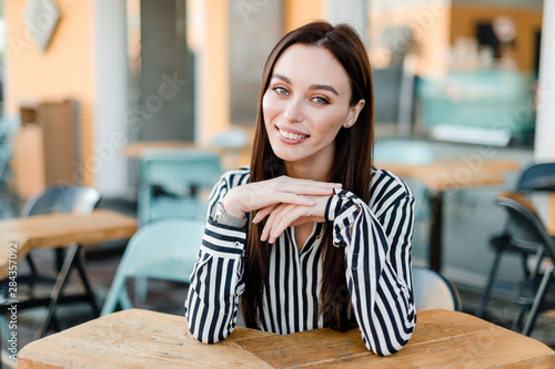 smiling woman sitting at cafe outdoors