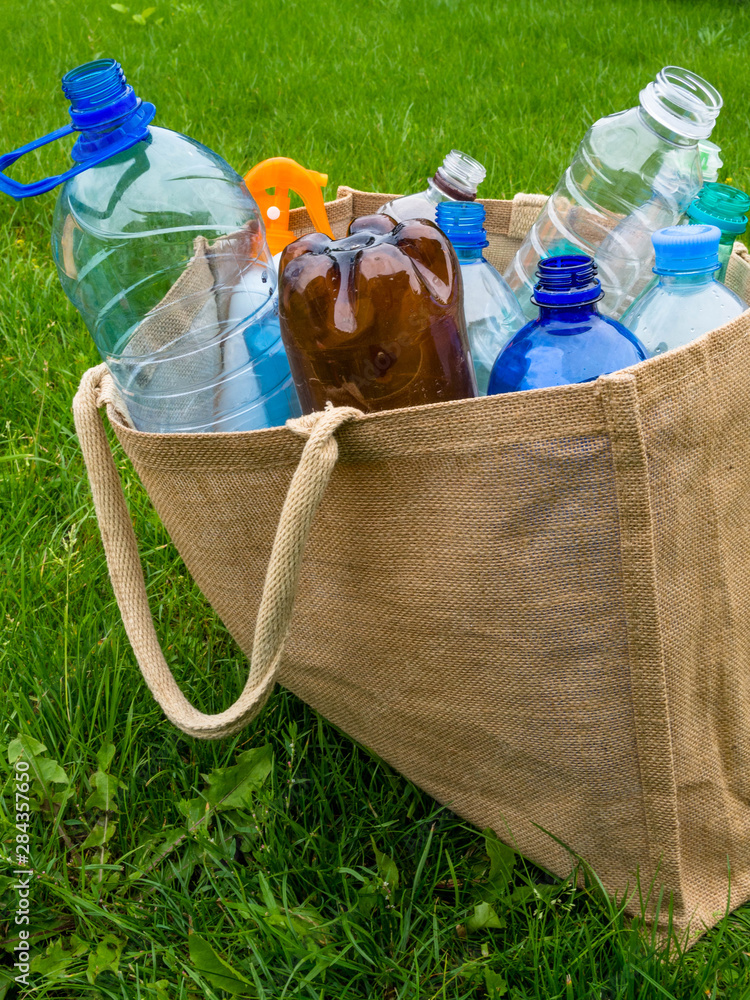 Fototapeta premium Ecological burlap bag and plastic bottles inside. Zero waste shopping concept.