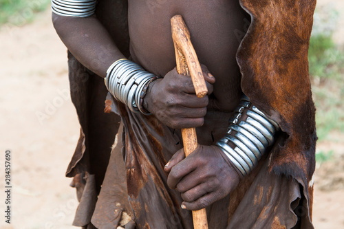 Africa, Ethiopia, Omo River Valley, South Omo, Hamer tribe. Hamer woman in traditional dress of goatskin and with metal bracelets.