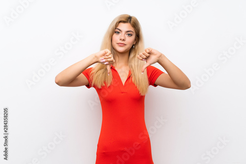 Teenager girl over isolated white background showing thumb down