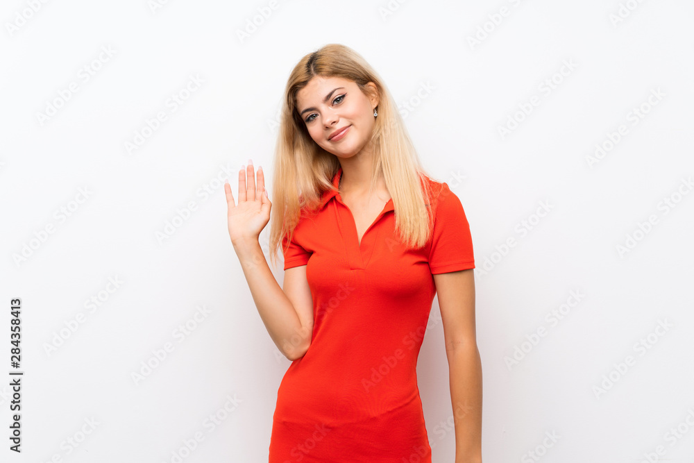 Teenager girl over isolated white background saluting with hand with happy expression Teenager girl over isolated white background saluting with hand with happy expression