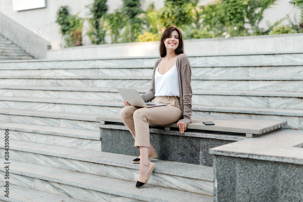 woman with laptop outdoor on the stairs