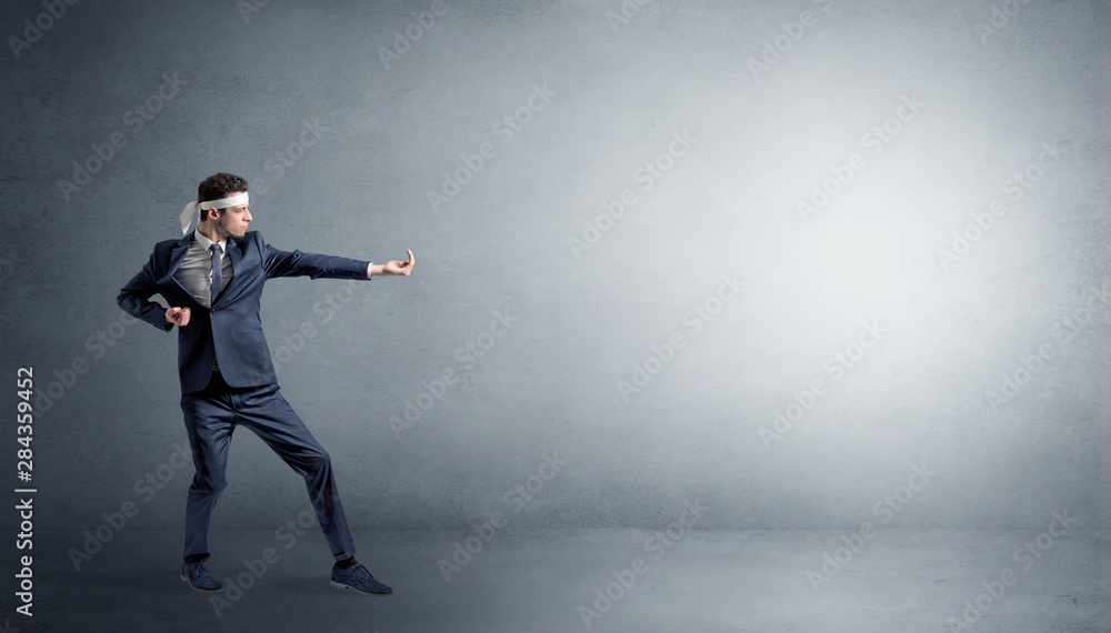 Small karate man fighting in an empty grey copy space Small karate man fighting in an empty grey copy space