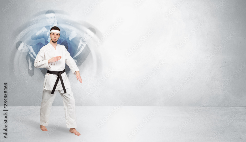 Young businessman in suit fighting with empty wall background Young businessman in suit fighting with empty wall background