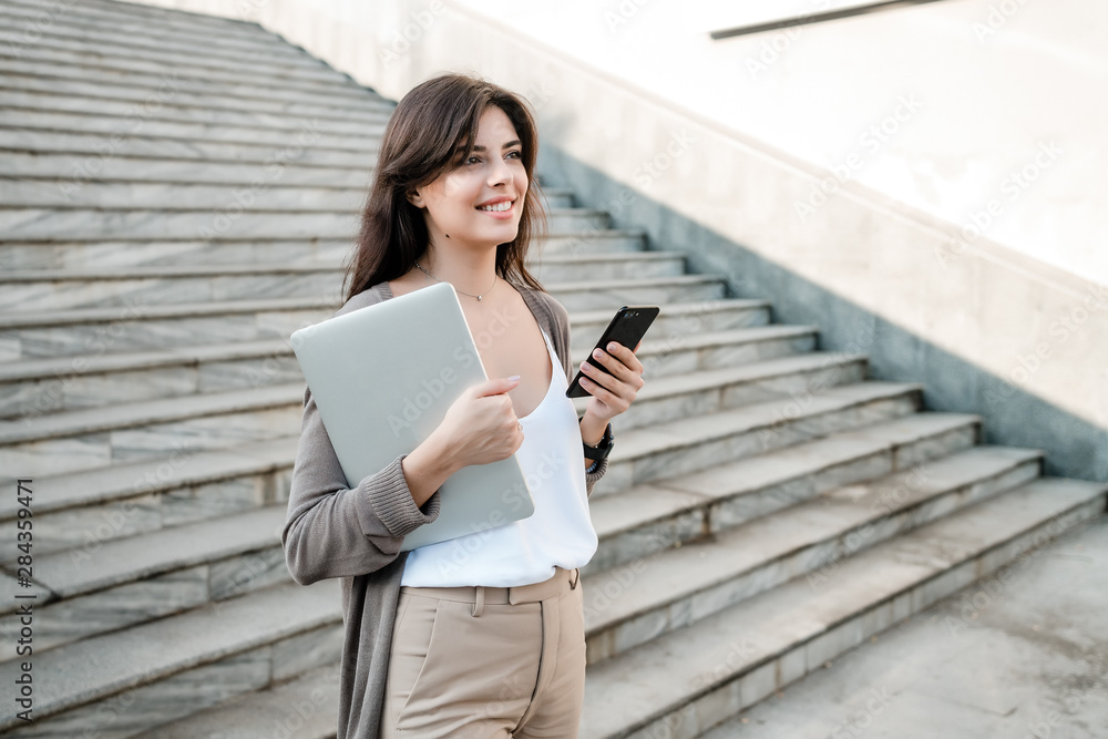 Fototapeta premium woman with laptop and phone in the city
