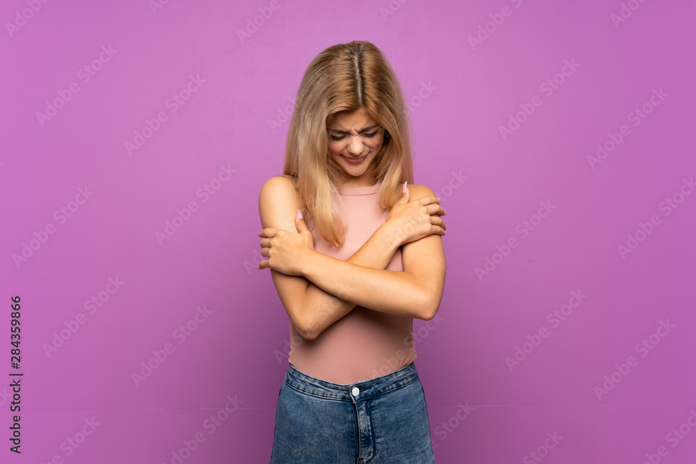 Teenager girl over isolated purple background freezing Teenager girl over isolated purple background freezing