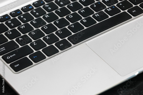 Closeup view of laptop keyboard on black background.