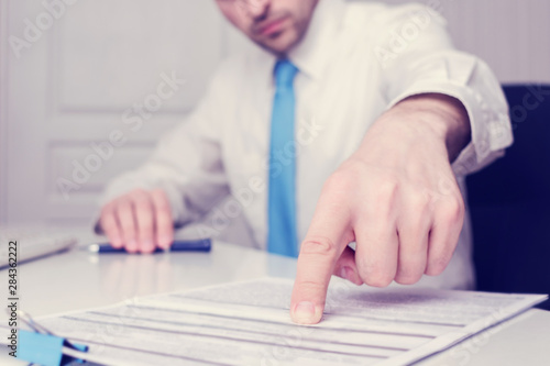 Boss indicates an error in the documents, men's hands, close up, toned
