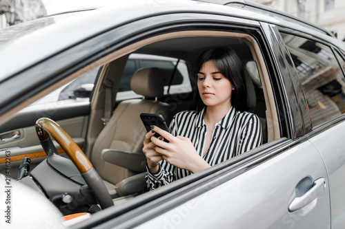 woman in car uses phone