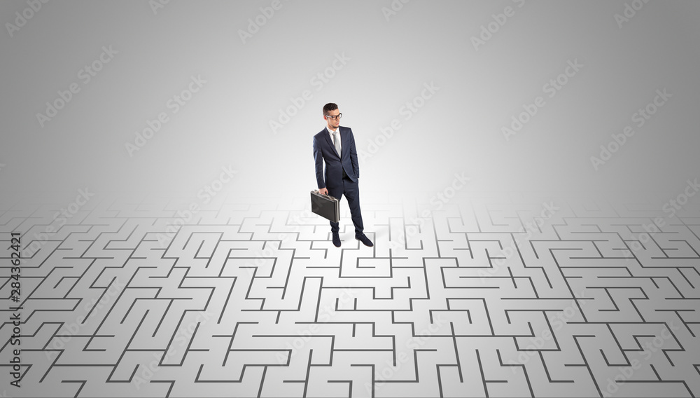 Elegant businessman looking for a solution in a middle of a maze Elegant businessman looking for a solution in a middle of a maze