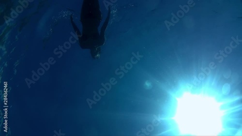 Wallpaper Mural Young woman swimming in the blue and clear sea. Young woman swimming underwater Torontodigital.ca