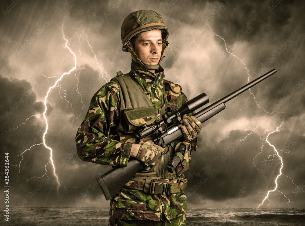 Armed soldier standing in rainy obscure weather Armed soldier standing in rainy obscure weather