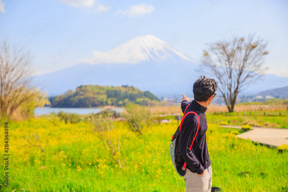 Fuji Mountain and a boy. Mt diamond fuji with snow and flower garden along the lake walkway at Kawaguchiko lake in japan, Mt Fuji is one of famous place in Japan. 