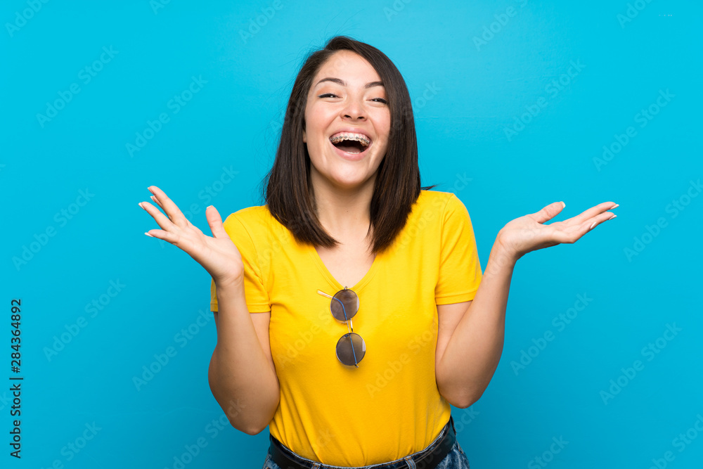 Young Mexican woman over isolated blue background with shocked facial expression Young Mexican woman over isolated blue background with shocked facial expression