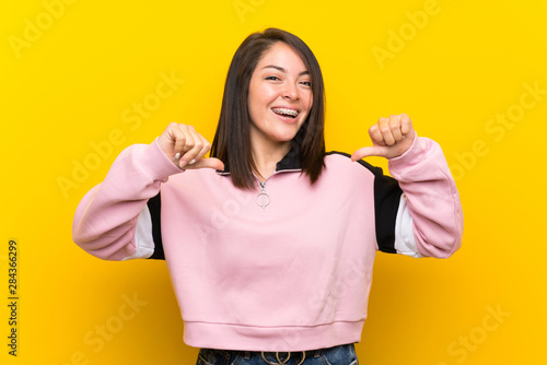 Young Mexican woman over isolated yellow background proud and self-satisfied
