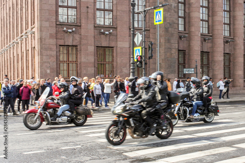 A group of motorcyclists at a speed passing by the audience.