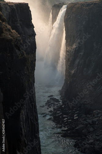 Africa, Zimbabwe, Victoria Falls. Waterfall and spray at sunrise.