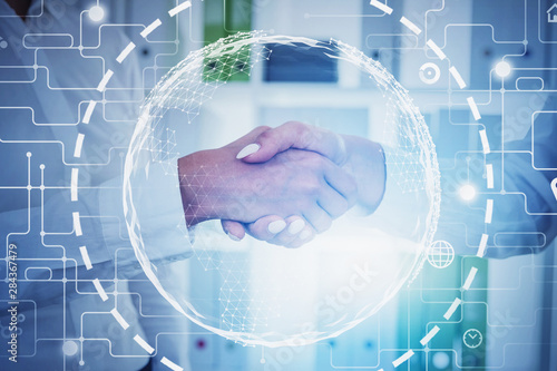 Women shaking hands in office, global connection photo