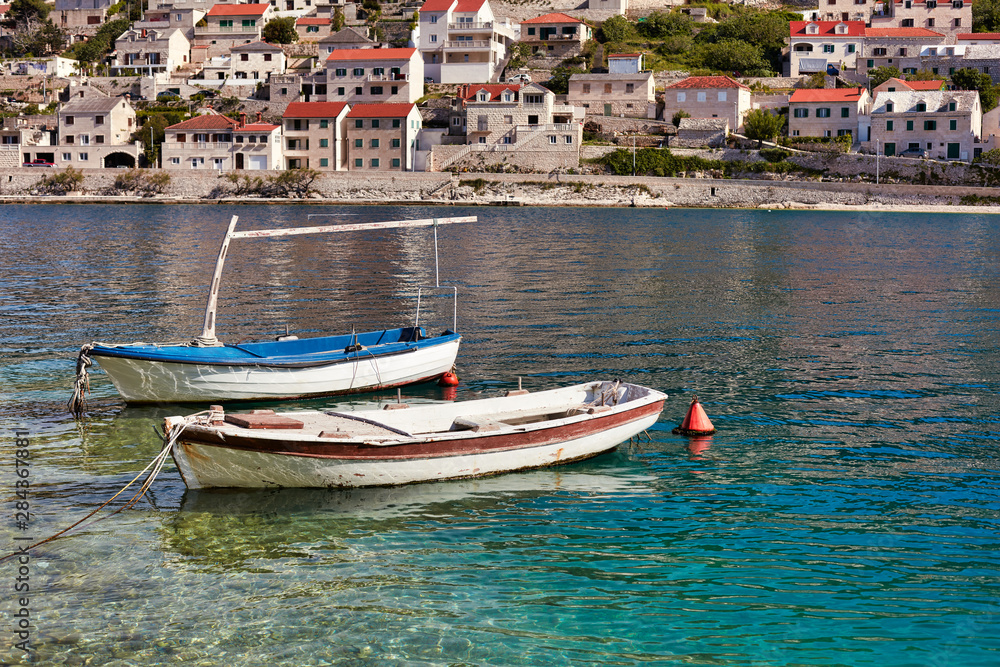 Pucisca, Brac Island, Croatia. Traditional fishing boat in the port. View of the city. The city famous from the sandstone from which the White House was built in Washington.