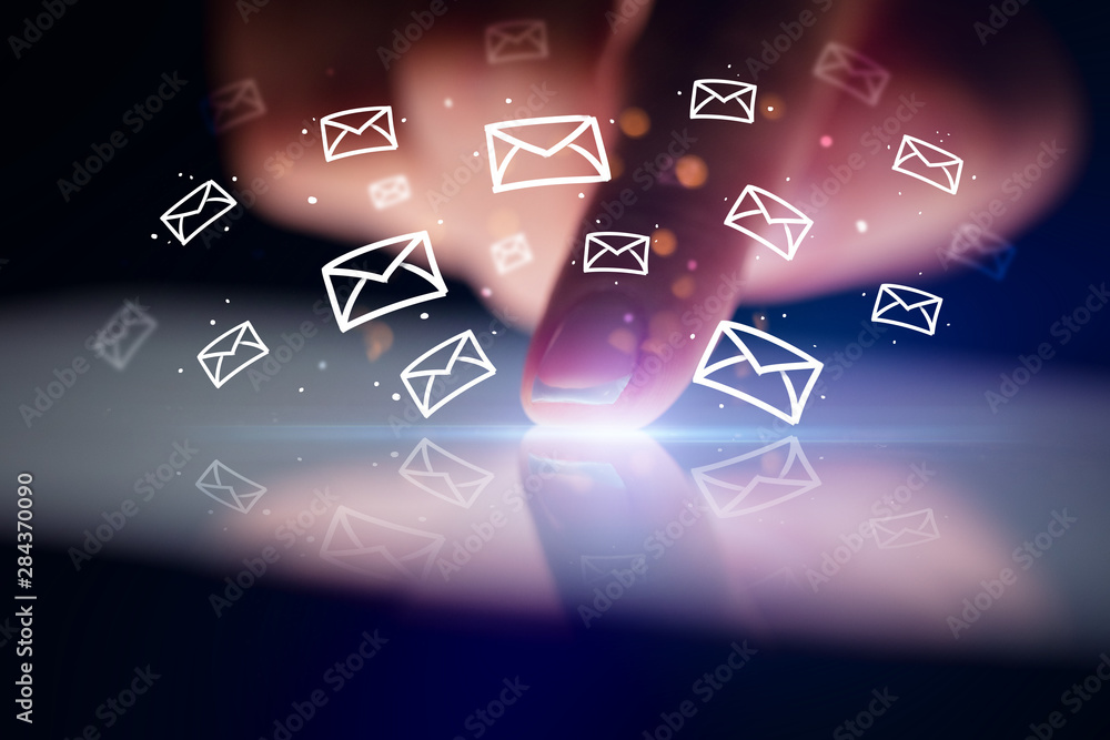 Finger touching tablet with white drawn mail icons above and dark background